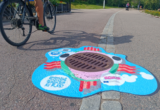 Mahanpuruja muovista tarra sadevesikaivon ympärillä.